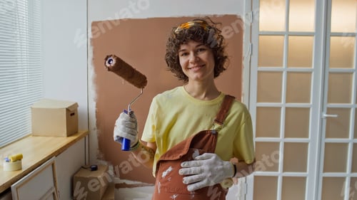 Preview: Smiling Woman Painting Wall with Roller Brush in Room