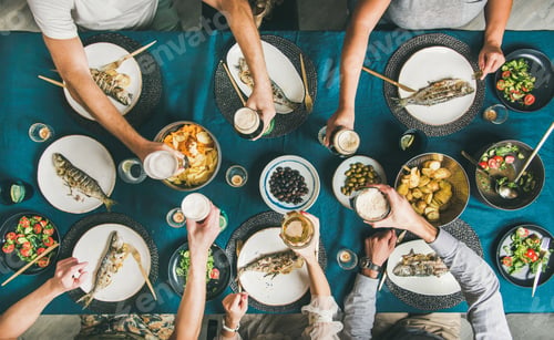 Preview: Flat-lay of people eating fish, drinking beer and celebrating together