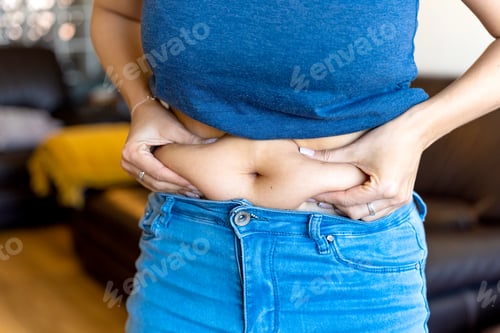 Preview: Woman pinching belly fat at home: overweight and dieting concept
