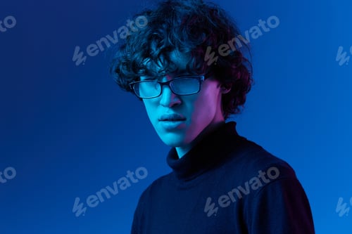 Preview: Man in black sweater model poses in glasses smile, hipster lifestyle, portrait blue background
