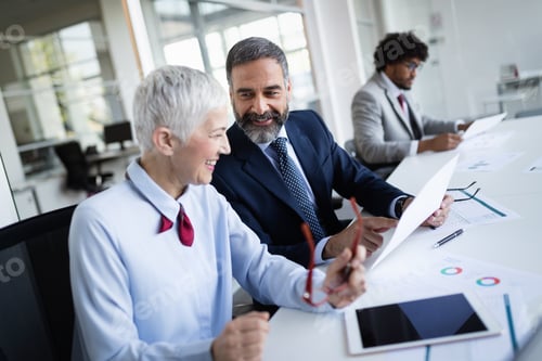 Preview: Portrait of happy business people discussing together in office