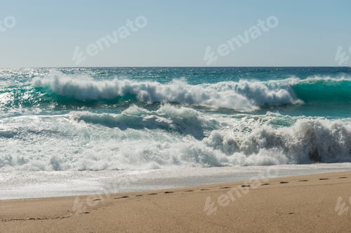 Preview: Waves crashing on a sandy beach.