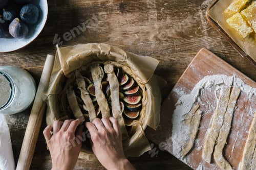 Preview: cropped shot of woman preparing delicious fig pie on rustic wooden table