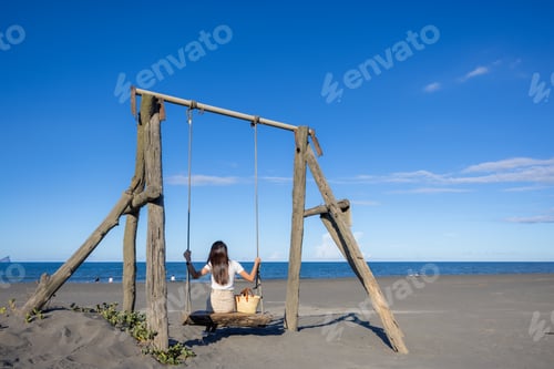 Preview: Woman play with swing on sand beach