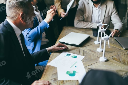 Preview: Business people working on sustainable innovation project - Focus on senior man hand