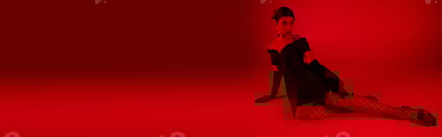 Preview: Woman Wearing Black Dress Posing in Red Studio