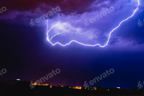 Preview: Rays in a night storm with light and clouds.