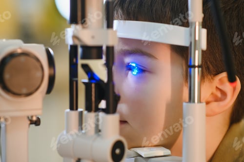 Preview: Ophthalmologist checking child's vision with modern equipment in clinic