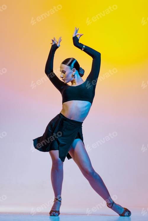 Preview: Stylish female dancer in black outfit posing in Latin dance move on vibrant gradient studio