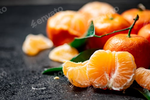 Preview: Peeled fresh tangerines. On a black background.