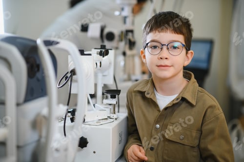 Preview: Boy wearing glasses undergoing vision diagnostics in ophthalmology clinic