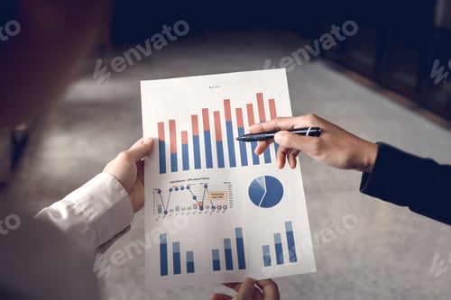 Preview: Rear view of colleagues examining business papers graph.