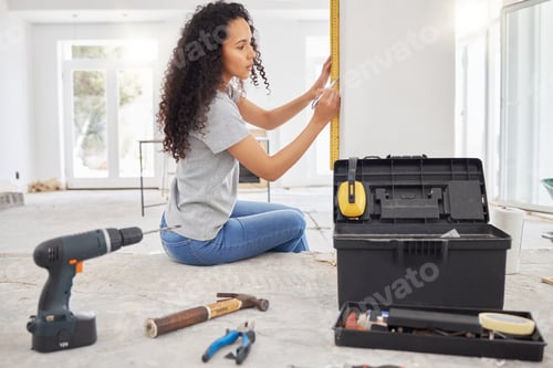 Preview: Its time for a home update. Shot of a woman using a spirit level while renovating a house.