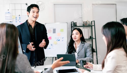 Preview: Confident businessman presenting data on screen to colleagues during a business meeting