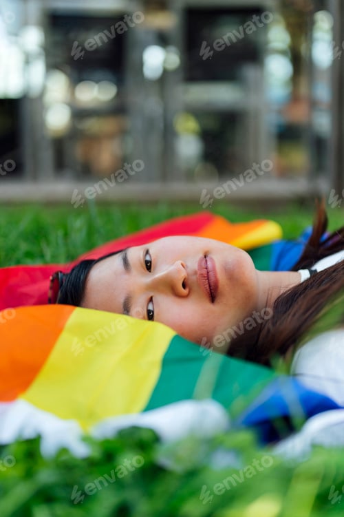 Preview: Beautiful relaxed young woman on rainbow flag
