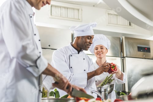 Preview: multicultural chefs preparing ripe vegetables at restaurant kitchen
