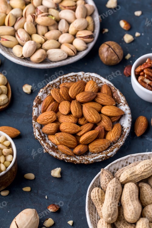 Preview: Assorted nuts in plates on a blue background top view