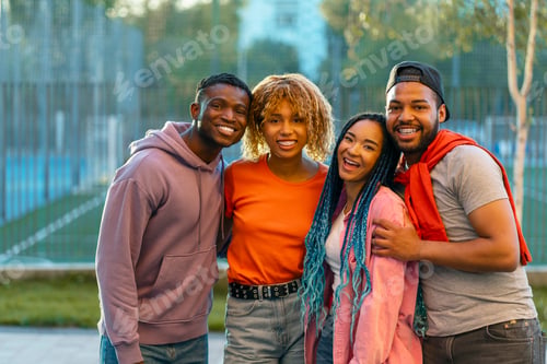 Preview: Young smiling stylish African American friends wearing casual clothing, hugging, looking at camera