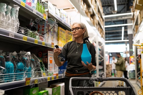 Preview: Woman shopping for cleaning supplies in a store on a weekday afternoon