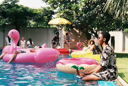 Preview: People sitting by the pool enjoying summer time