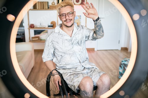 Preview: Smiling Man Sitting in Wheelchair Waving at Camera