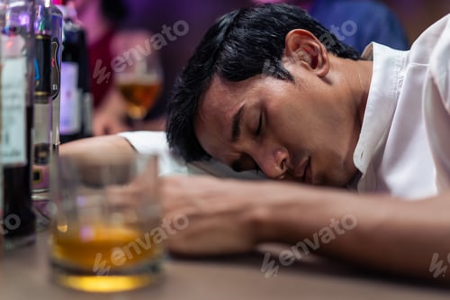 Preview: Asian depression man feeling heart broken and drinking beer in a bar.