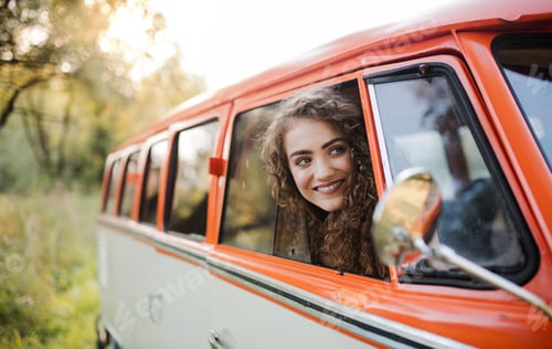 Preview: A young girl looking out of a car on a roadtrip through countryside.