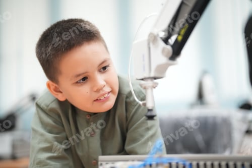 Preview: Concentrated teen child programming robot at class, stem education concept.