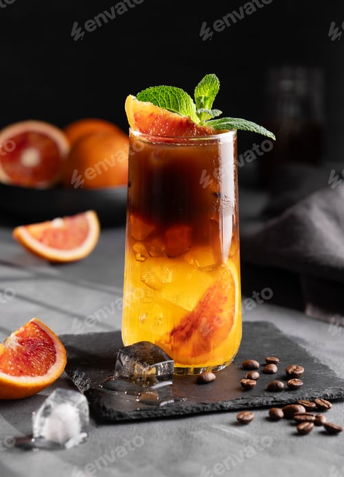 Preview: Coffee with orange juice (bumble) in a tall glass with ice and mint on a dark background