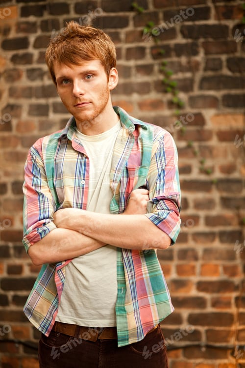 Preview: Portrait of young man in front of brick wall