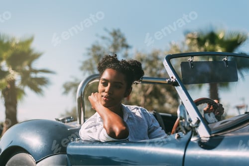 Preview: Black woman driving a vintage convertible car