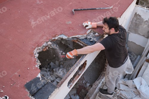 Preview: Young man tearing the ceiling of a house down.