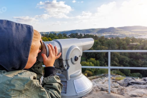 Preview: Cute curious kid boy observing Saxony national park Harz landscape with coin-operated observing