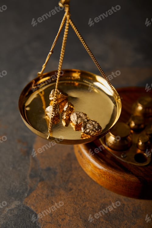 Preview: golden stones on scales on marble table