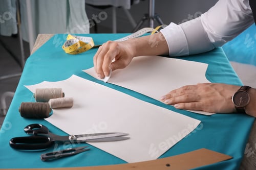 Preview: Tailor working at table in atelier, closeup
