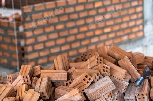 Visualização: Pilha de tijolos se preparando para alvenaria sobre a foto desfocada do fundo da parede de tijolos,