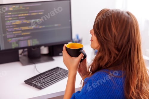 Preview: Female programmer taking coffee break while working remotely from home
