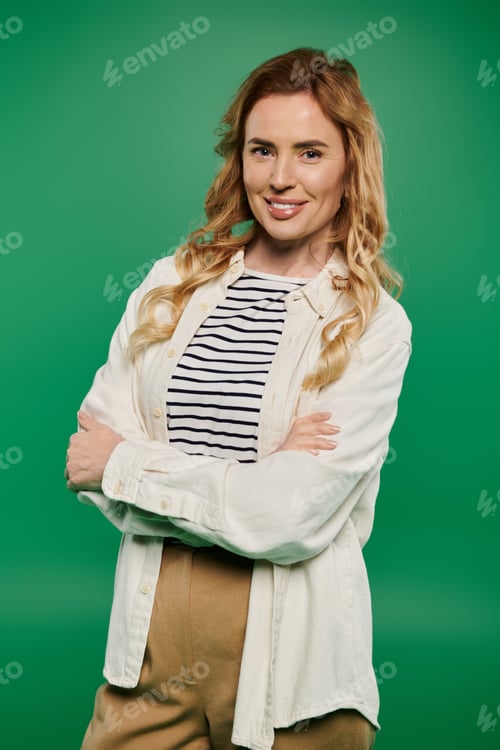 Preview: A confident woman stands against a bright green background