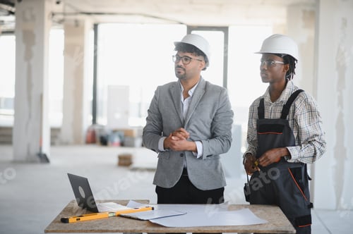 Preview: Architect and builder discussing plans on construction site