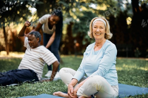 Preview: Happy senior woman having exercise class in nature and looking at camera.