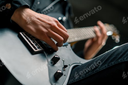 Preview: rock performer with electric guitar in recording studio creating song musical instrument strings
