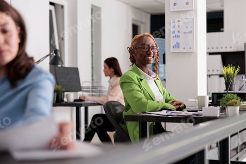 Preview: Successful employee in co working space, looking at camera