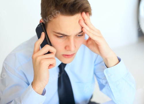 Preview: Young pensive businessman talking on cell phone
