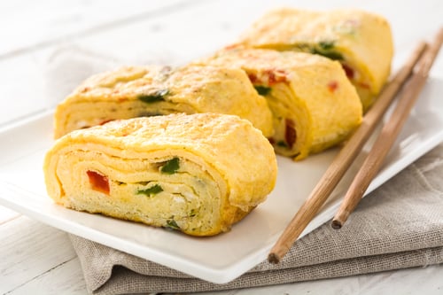 Preview: Tamagoyaki, japanese rolled omelette, sliced and ready to eat with chopsticks