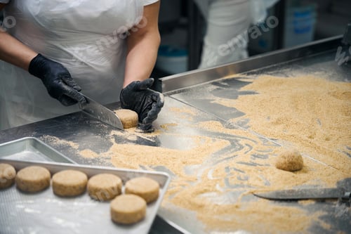 Preview: Female forms a cutlet in breadcrumbs on a metal surface