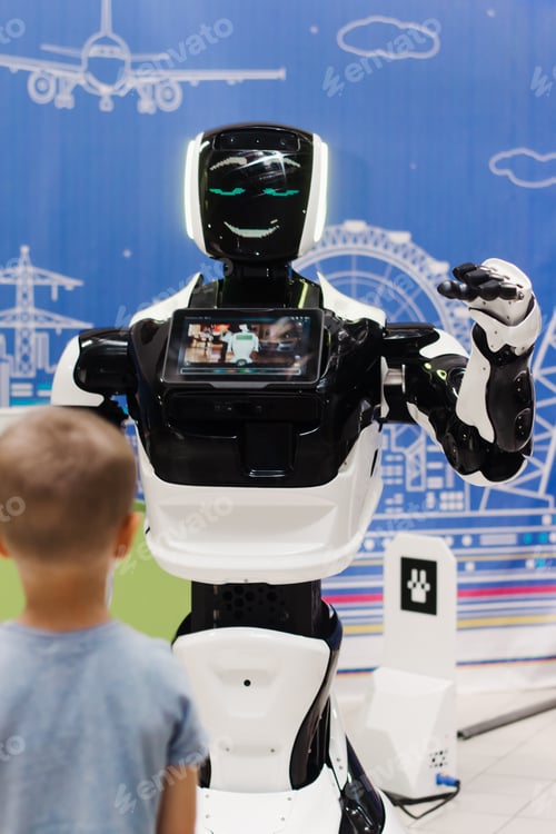 Preview: A boy looks at a robot at a robot exhibition.Artificial intelligence, the concept of the future.