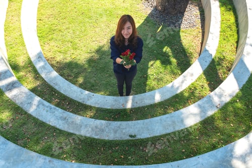 Preview: A woman holding red roses flower in green garden with feeling happy on Valentine's day