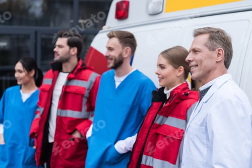 Preview: ambulance doctors working team smiling and standing in front of car