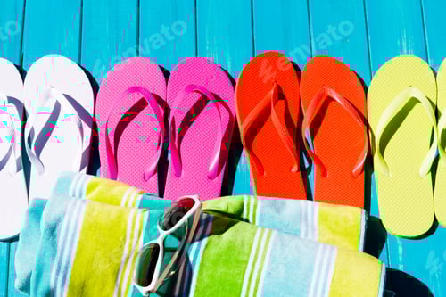 Preview: Colorful Beach Flip-Flops and Towel on Blue Deck
