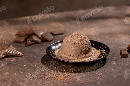 Preview: Scoop of chocolate ice cream with chocolate sprinkles on a black plate